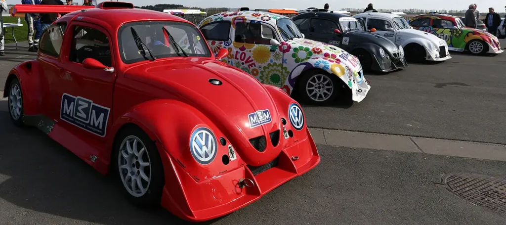 Enfilade de cinq modèles différents de VW Fun Cup alignés en 3/4 face sur la ligne de départ.