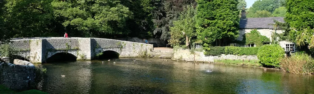 Le pont Sheepwash Bridge en pierre enjambant la rivière Wye à Ashford-in-the-Water dans le Peak District.