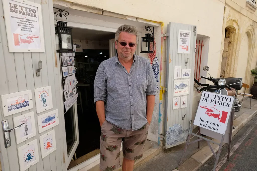 Portrait d'Étienne devant son atelier Le Typo du Panier lors d'une journée à Marseille.