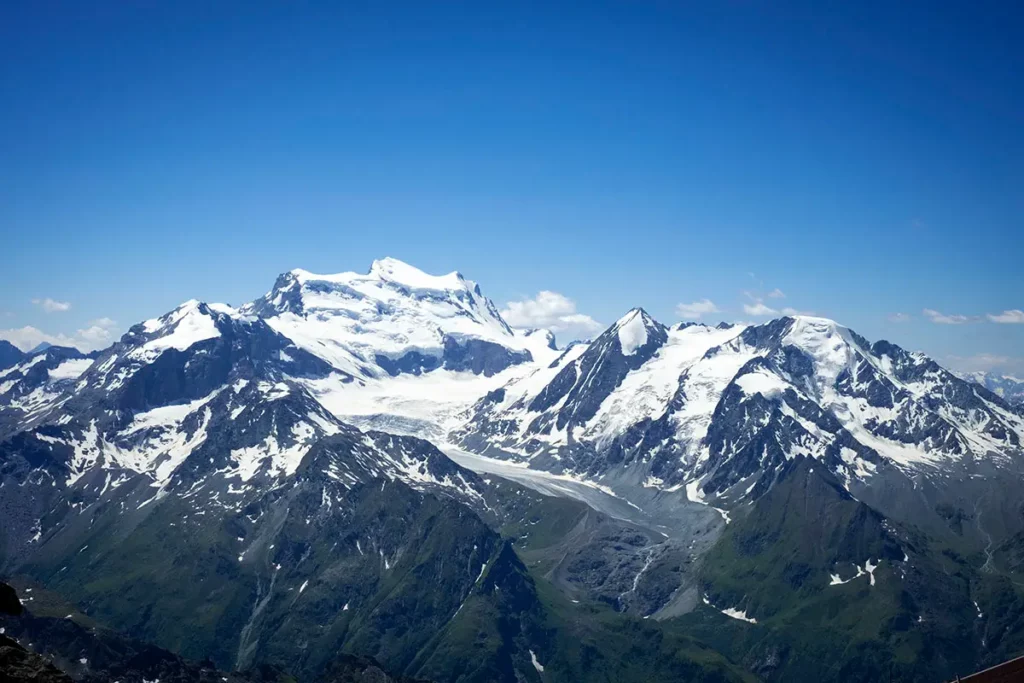 Vue panoramique sur le massif du Grand Combin et du Petit Combin en été montrant le recul du glacier dans le Valais.