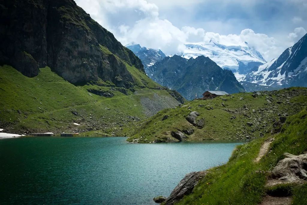 Vue panoramique du lac de Louvie avec son refuge traditionnel en arrière-plan, Val de Bagnes, Suisse.