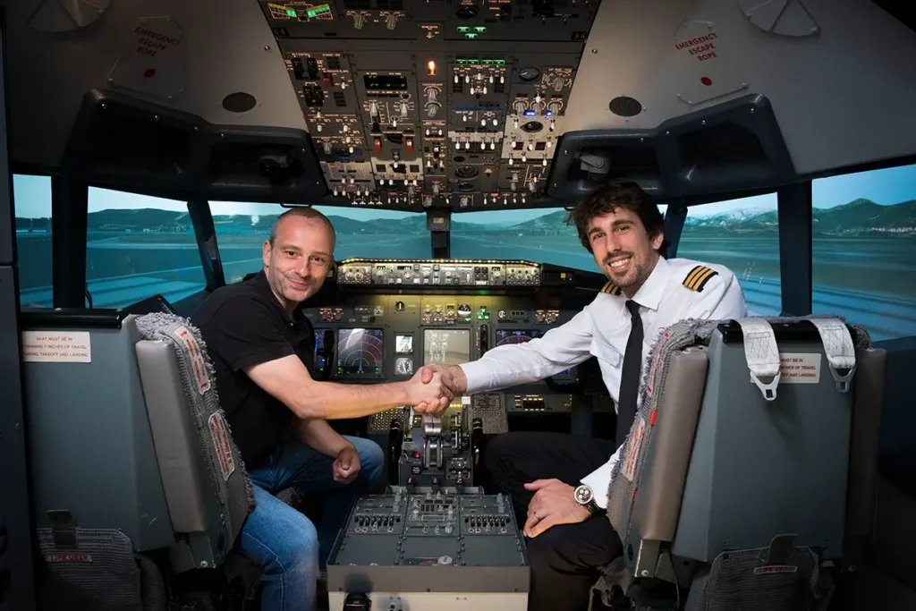 Michel Gronemberger et Tanguy Warny se serrant la main dans le cockpit du Boeing 737-800 après la session de pilotage chez European Flight Simulator.