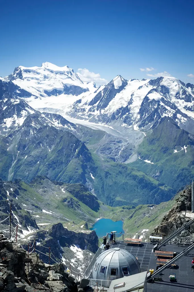Photo verticale du sommet du Mont-Fort (3330m) avec sa coupole et l'arrivée des télécabines, vue sur le Grand et Petit Combin.