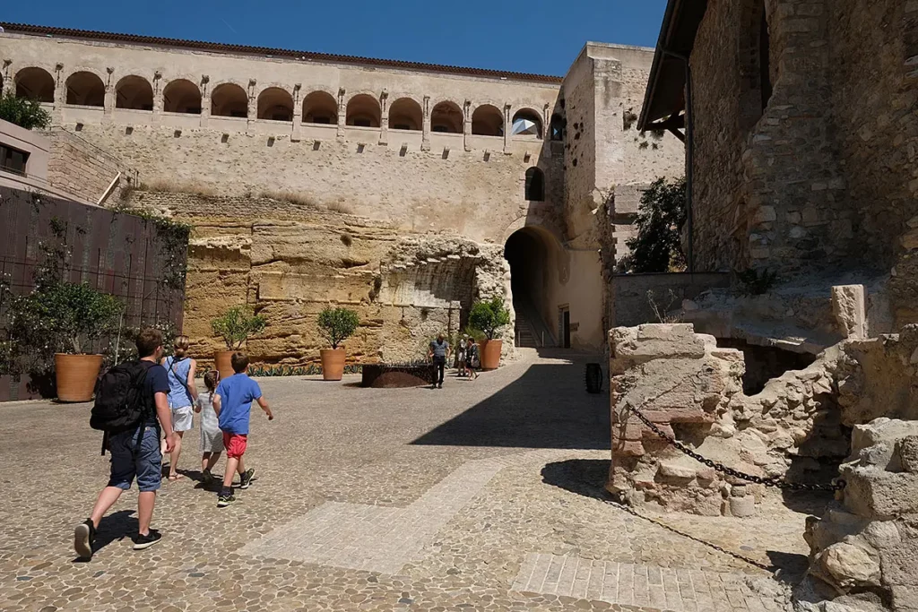 Une famille se promenant dans les allées historiques du Fort Saint-Jean à Marseille.