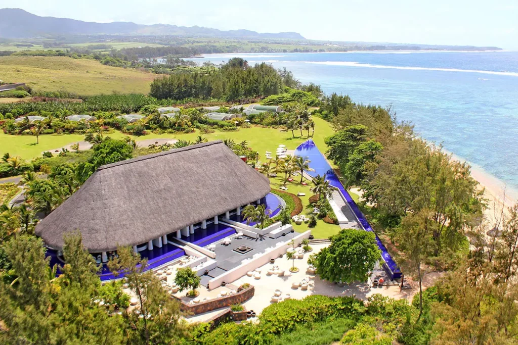 Vue aérienne du restaurant au toit de chaume et de la piscine en forme de machette au milieu de la végétation tropicale du So Sofitel Mauritius.