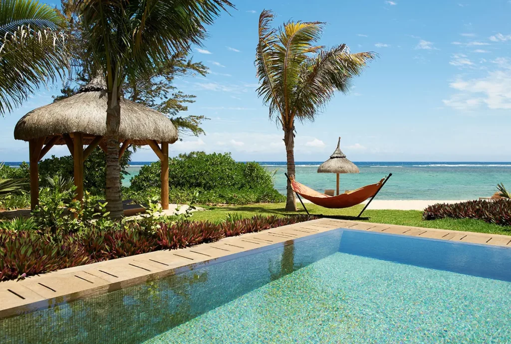 Vue depuis la piscine privée d'une So VIP Villa au So Sofitel Mauritius avec hamac, jardin tropical et lagon turquoise de Bel Ombre.