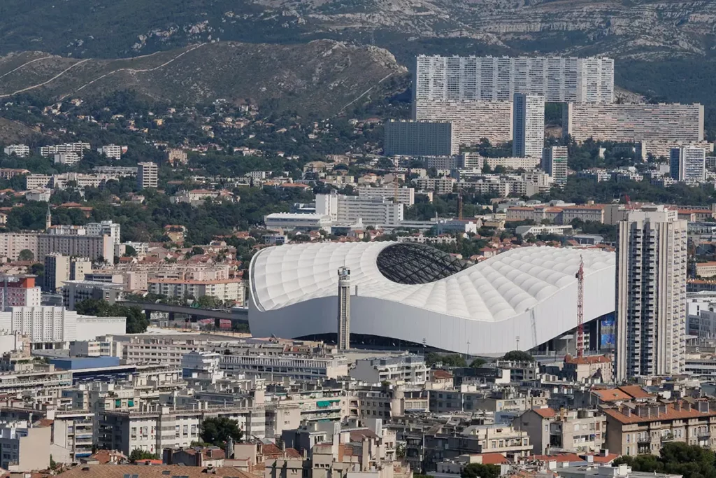 Vue panoramique sur le Stade Vélodrome et les quartiers de la ville lors d'une journée à Marseille.
