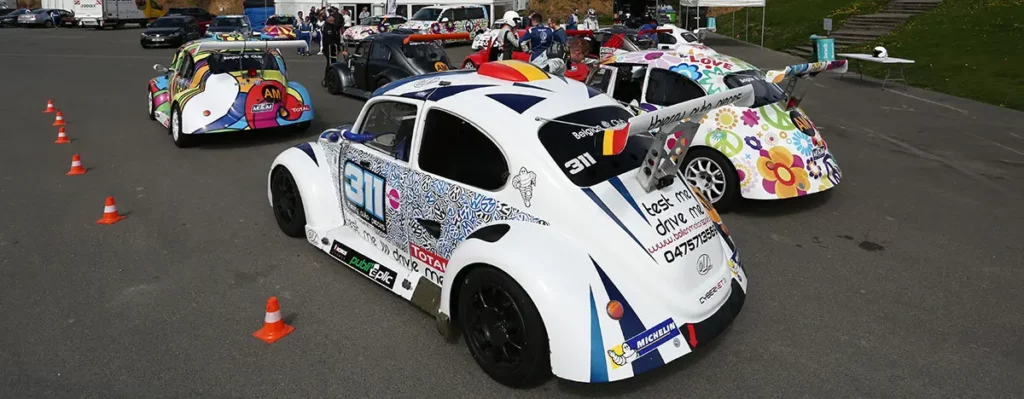 Alignement arrière de VW Fun Cup colorées et sponsorisées avec leurs larges ailerons caractéristiques avant le départ.