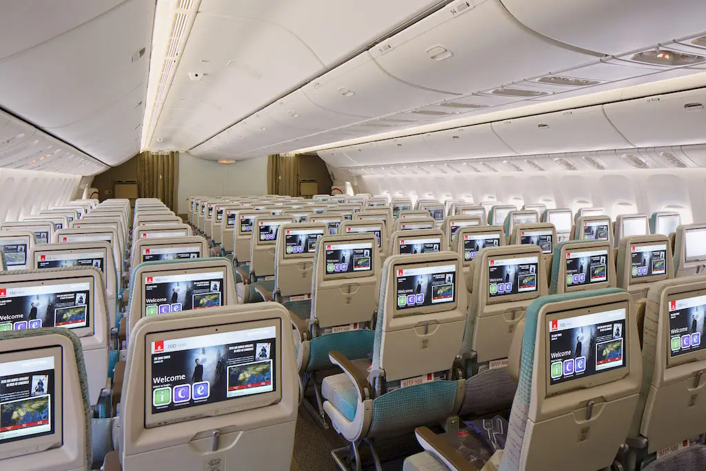 Vue de l'arrière de la cabine Économique du Boeing 777 montrant les écrans individuels du système de divertissement ice.