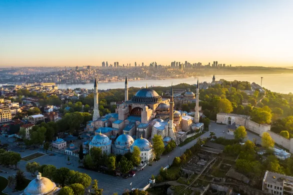 Road-trip en Turquie, vue aérienne de la mosquée Sainte-Sophie à Istanbul, avec le détroit du Bosphore et les gratte-ciels modernes en arrière-plan.
