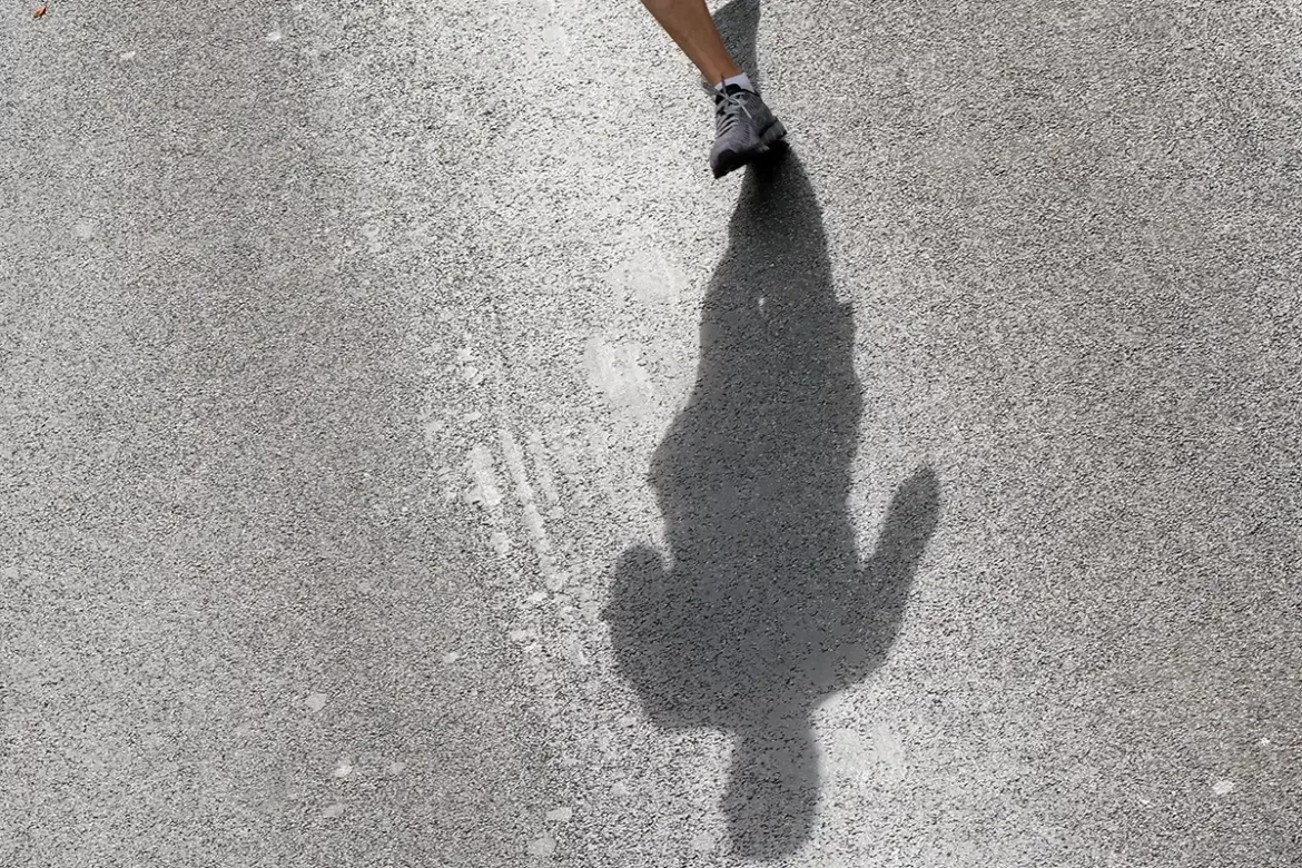 Ombre chinoise d'un coureur sur le bitume ensoleillé pendant les 20 km de Bruxelles.