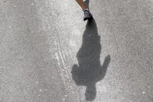 Ombre chinoise d'un coureur sur le bitume ensoleillé pendant les 20 km de Bruxelles.