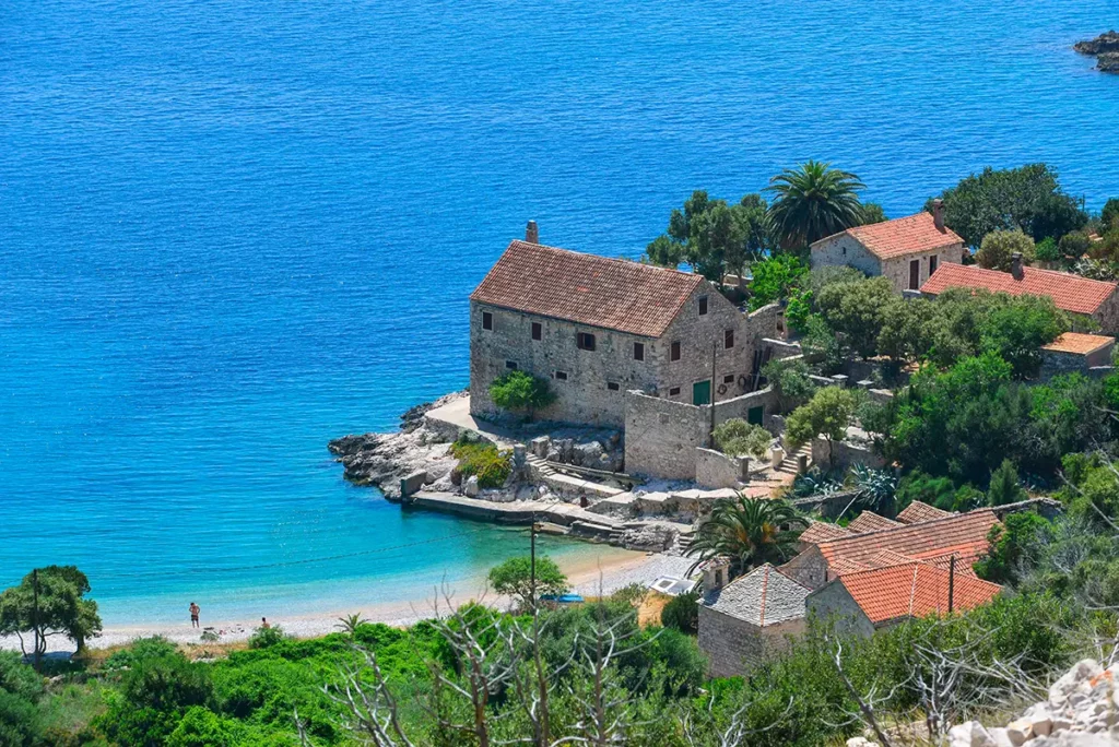Vue en contrebas de la plage de Dubovica sur l'île de Hvar, une crique de galets typique des îles croates avec sa maison en pierre traditionnelle.