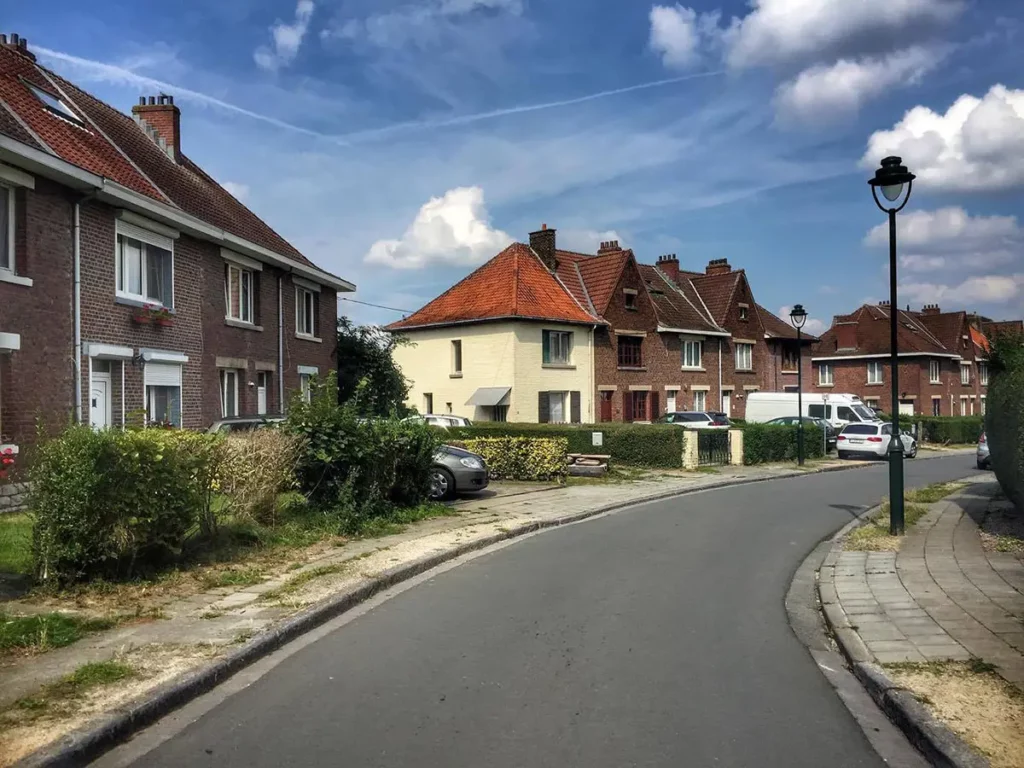 Sentier de la Promenade Verte empruntant une rue calme de la Cité-jardin du Bon Air à Anderlecht, bordée de maisons typiques.