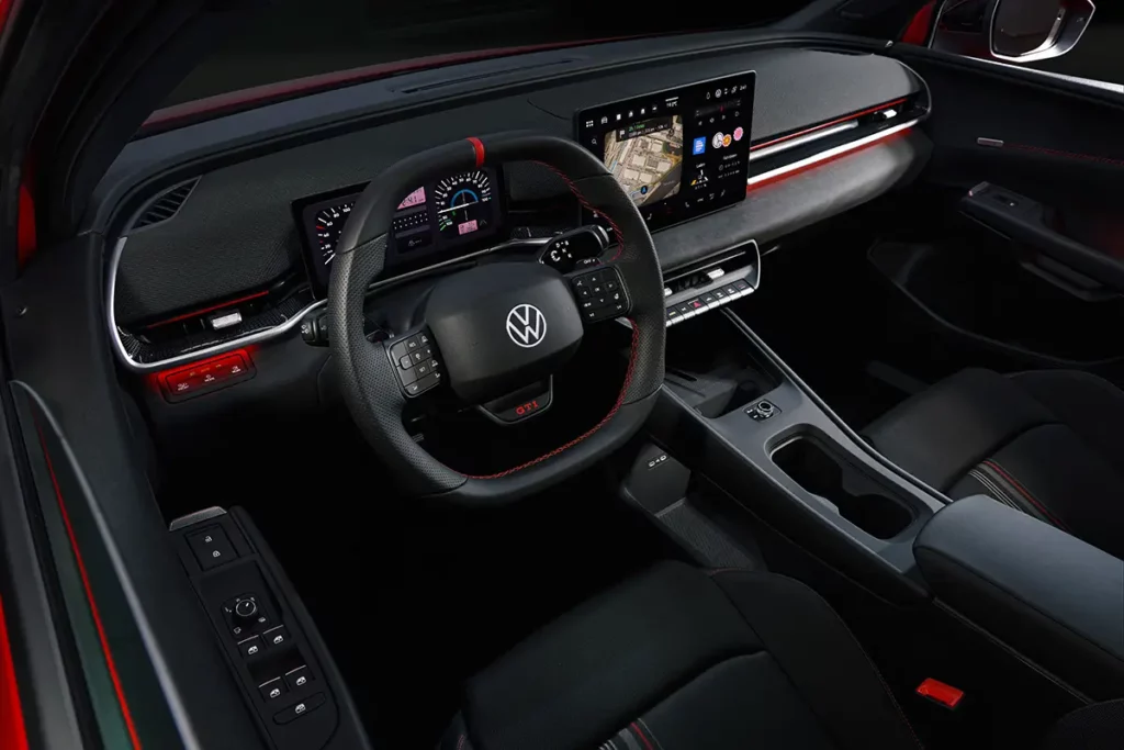 Vue de l'habitacle d'une Volkswagen ID. Polo GTI électrique montrant le compteur digital en mode rétro Golf GTI et l'écran central avec la carte de navigation.