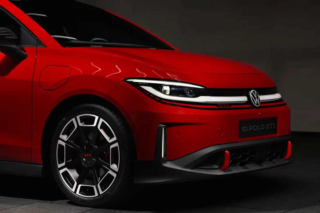Gros plan de trois-quarts avant sur l'optique IQ.LIGHT allumé et la jante d'une Volkswagen ID. Polo GTI électrique rouge.