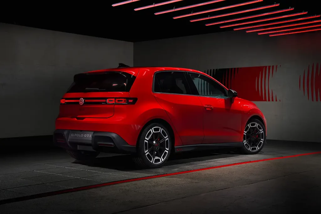 Vue de trois-quarts arrière de la Volkswagen ID. Polo GTI électrique rouge, mettant en valeur son profil racé et son design contemporain dans un garage futuriste.