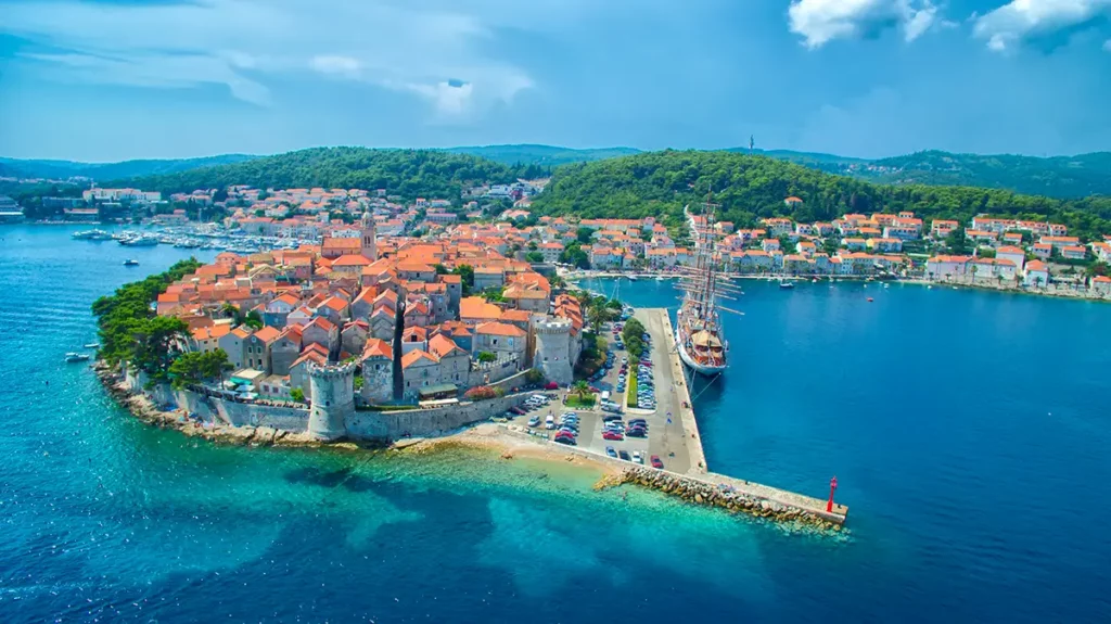 Vue aérienne de la vieille ville fortifiée de Korčula et de son port, une escale historique incontournable parmi les îles croates.