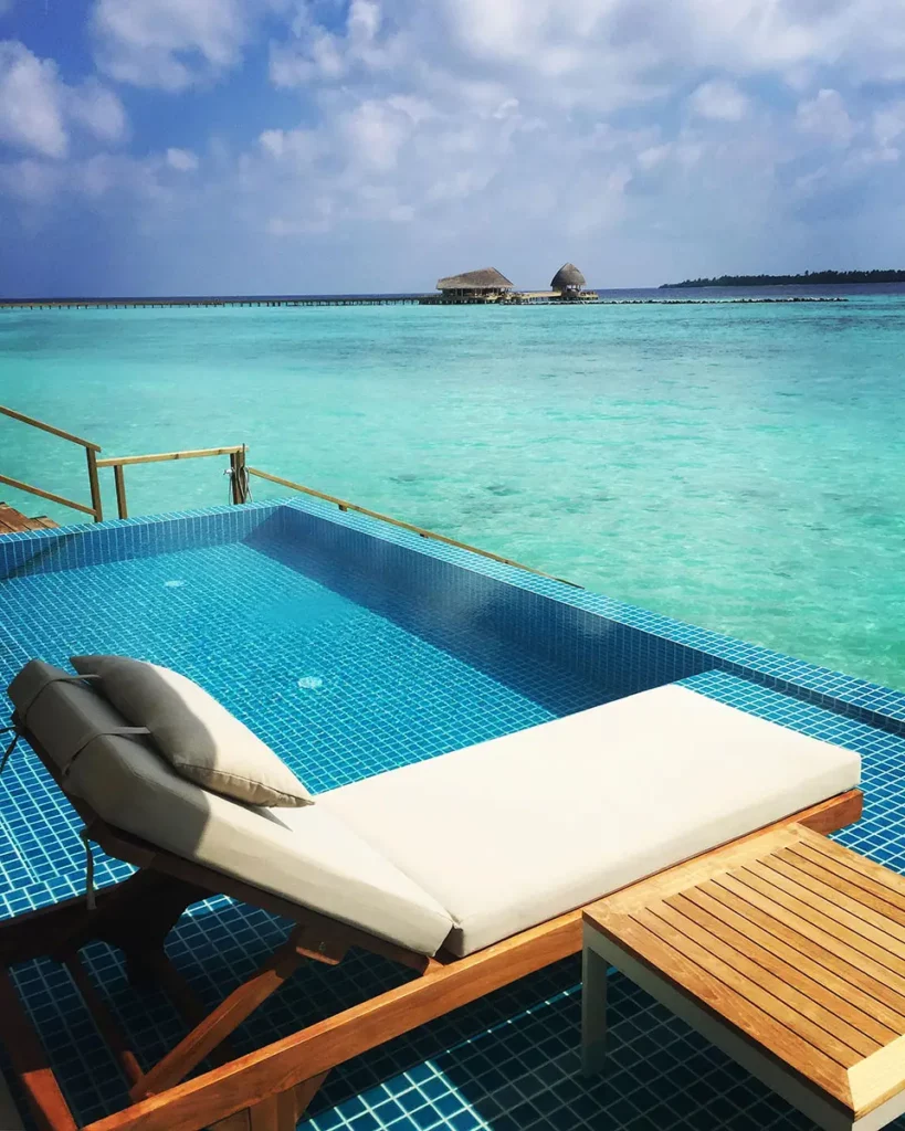 Vue verticale depuis la terrasse de ma Water Villa à Emerald Faarufushi, montrant le contraste entre le premier plan de la terrasse, la piscine privée et l'horizon de l'Océan Indien.