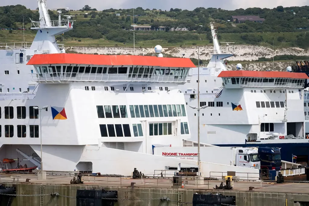 Focus sur l'avant de deux ferries en enfilade dans le port de Douvres, l'un chargé avec deux camions sur le pont et l'autre vide à côté.