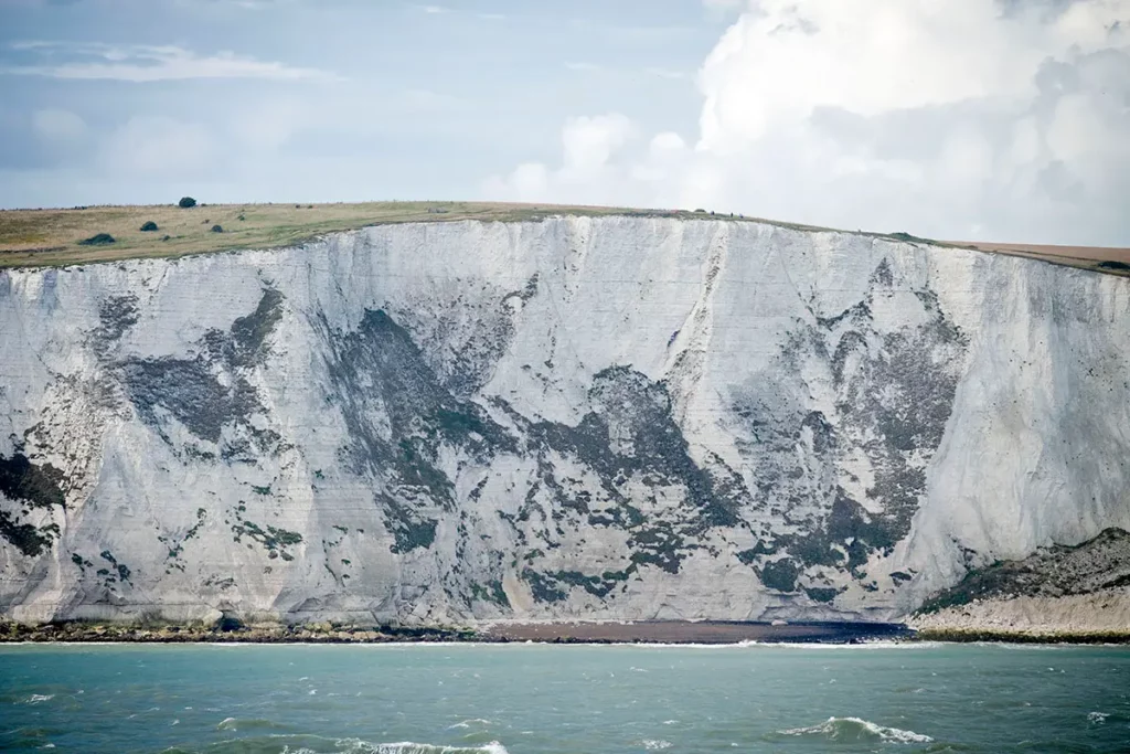 Immense falaise blanche de Douvres de plus de 100 mètres de hauteur, occupant tout l'espace entre la mer en bas et le ciel en haut.