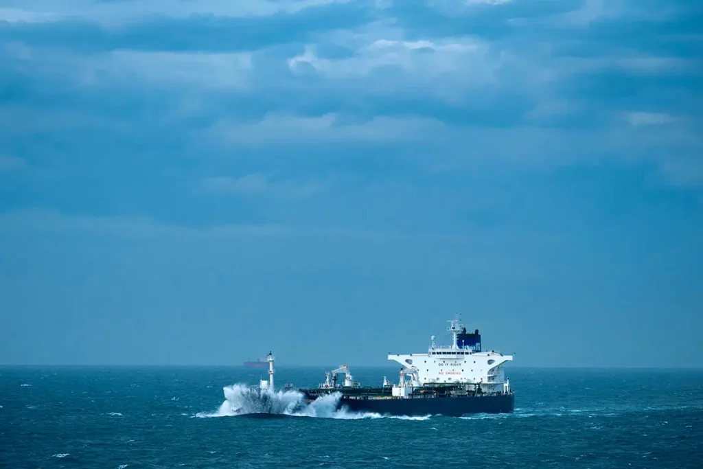 Un méthanier très bas dans l'eau fendant les vagues avec l'inscription "No Smoking" en grand sur le blanc de sa timonerie.