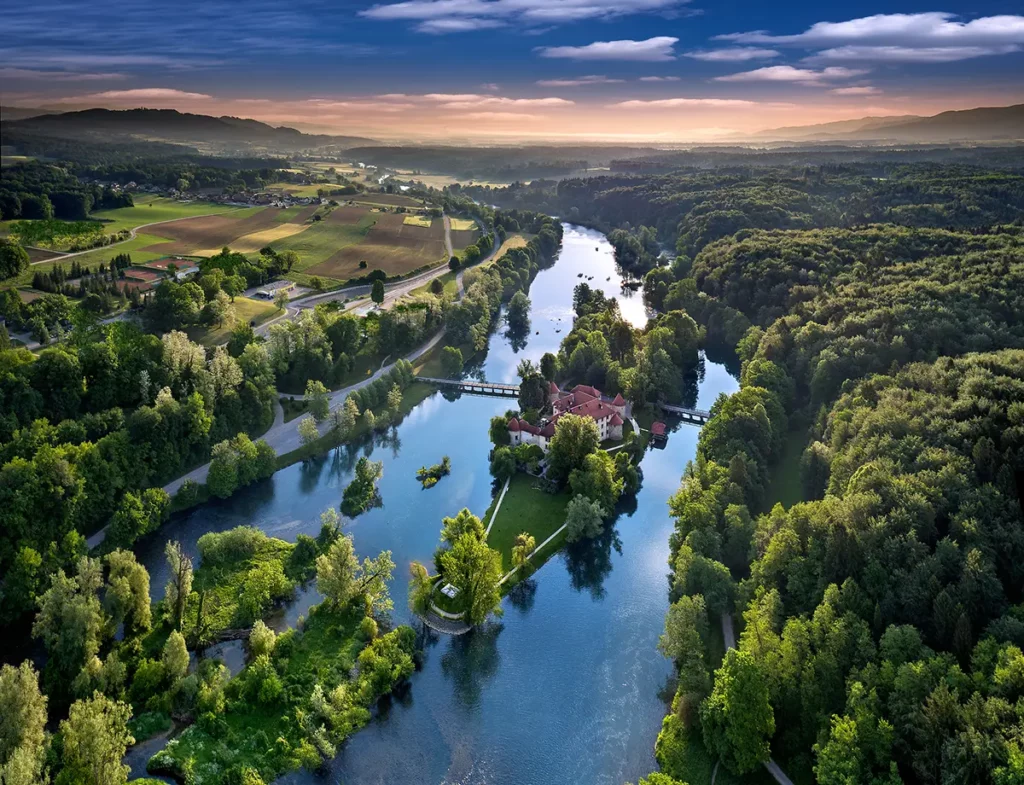 Vue aérienne du château médiéval d'Otočec sur son île au milieu de la rivière Krka pendant un road-trip en Slovénie.