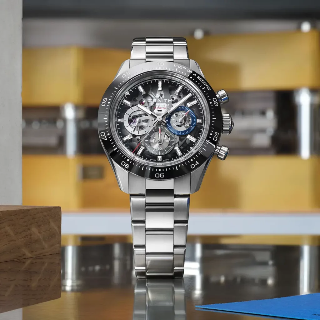 Vue de face de la montre Zenith Chronomaster Sport Skeleton en acier avec lunette en céramique noire dans un atelier horloger.