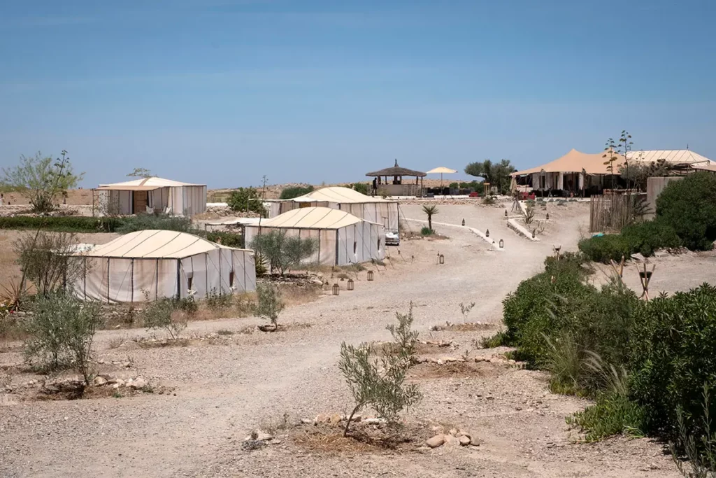 Allée centrale et tentes lodge sous le soleil au domaine Terre des Étoiles dans le désert d'Agafay