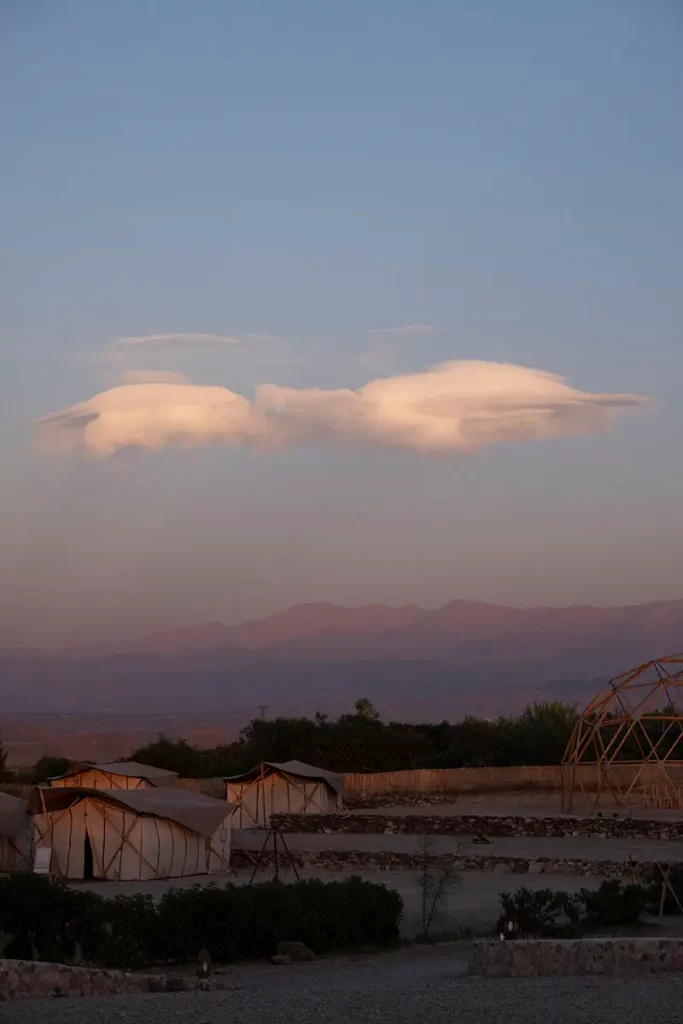 Nuage lenticulaire en forme d'oiseau au-dessus des tentes de Terre des Étoiles dans le désert d'Agafay