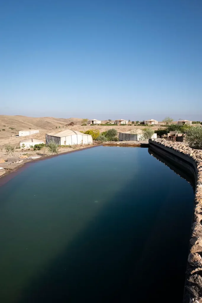 Piscine menant vers les tentes lodge et les collines du désert d'Agafay à Terre des Étoiles