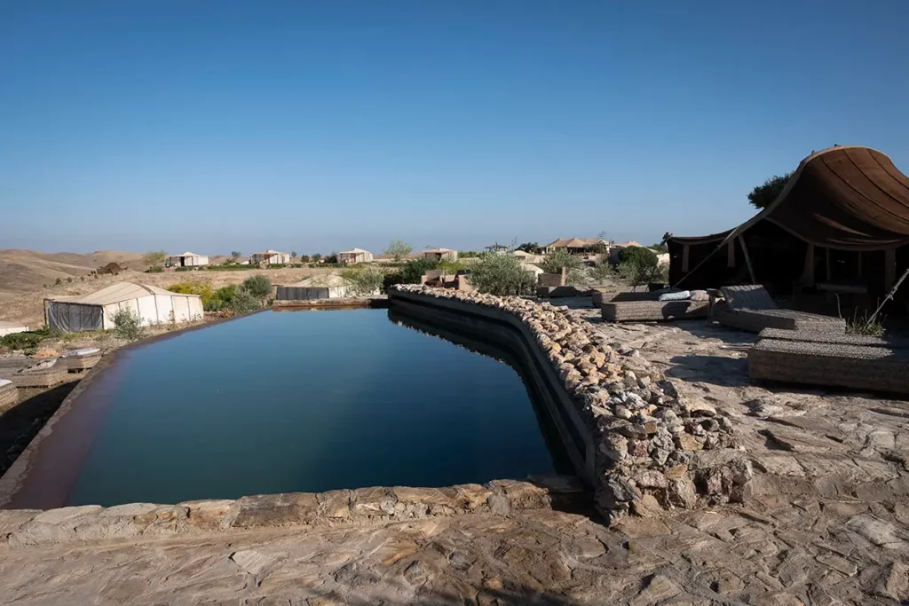 Piscine, transats et tentes lodge de l'oasis Terre des Étoiles dans le désert d'Agafay
