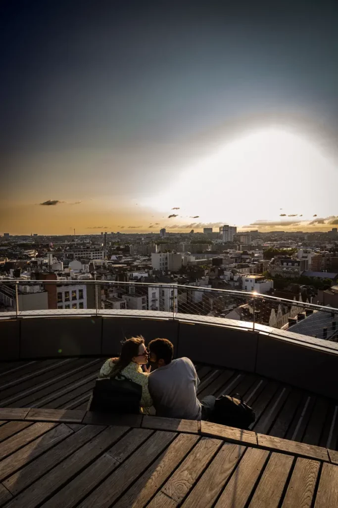 Vue verticale d'un couple s'embrassant sur la terrasse sud-est du rooftop 58 devant le coucher de soleil sur Bruxelles