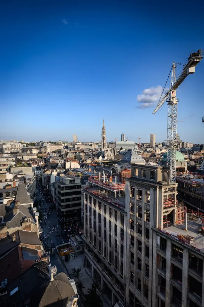 Vue verticale au grand-angle depuis le rooftop 58 sur la façade en travaux de la rue Marché aux Poulets et panorama de Bruxelles le 21 juillet