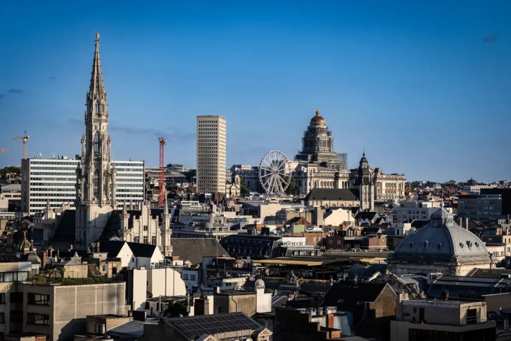 Zoom horizontal depuis le rooftop 58 sur le panorama de Bruxelles incluant la Bourse, la tour du Sablon et la grande roue