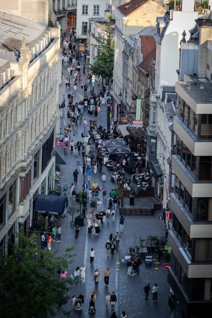 Gros plan vertical au téléobjectif depuis le rooftop 58 sur l'animation de la rue Marché aux Poulets