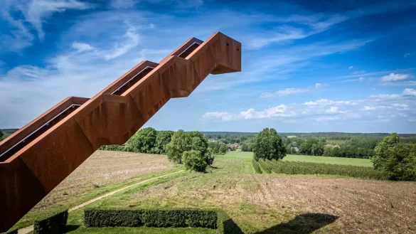 Vlooybergtoren photographiée de plus près par drone avec les marches en acier Corten au premier plan et la vallée du Hageland en arrière-plan