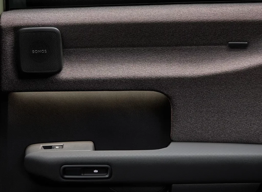 Gros plan sur le panneau de porte de l'Audi A2 e-tron, mettant en valeur le revêtement textile Softwrap, la poignée et le haut-parleur Sonos intégré