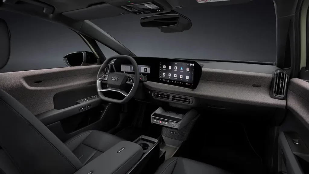 Vue intérieure de l'Audi A2 e-tron sous un angle trois-quarts, mettant en valeur le poste de conduite orienté vers le conducteur, la planche de bord en Softwrap et le double écran MMI