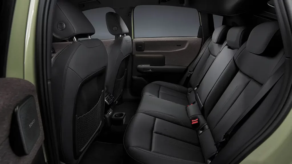 Vue de la banquette arrière et de l'espace à bord de l'Audi A2 e-tron, montrant les sièges arrière en cuir sombre et les contre-portes habillées de textile Softwrap