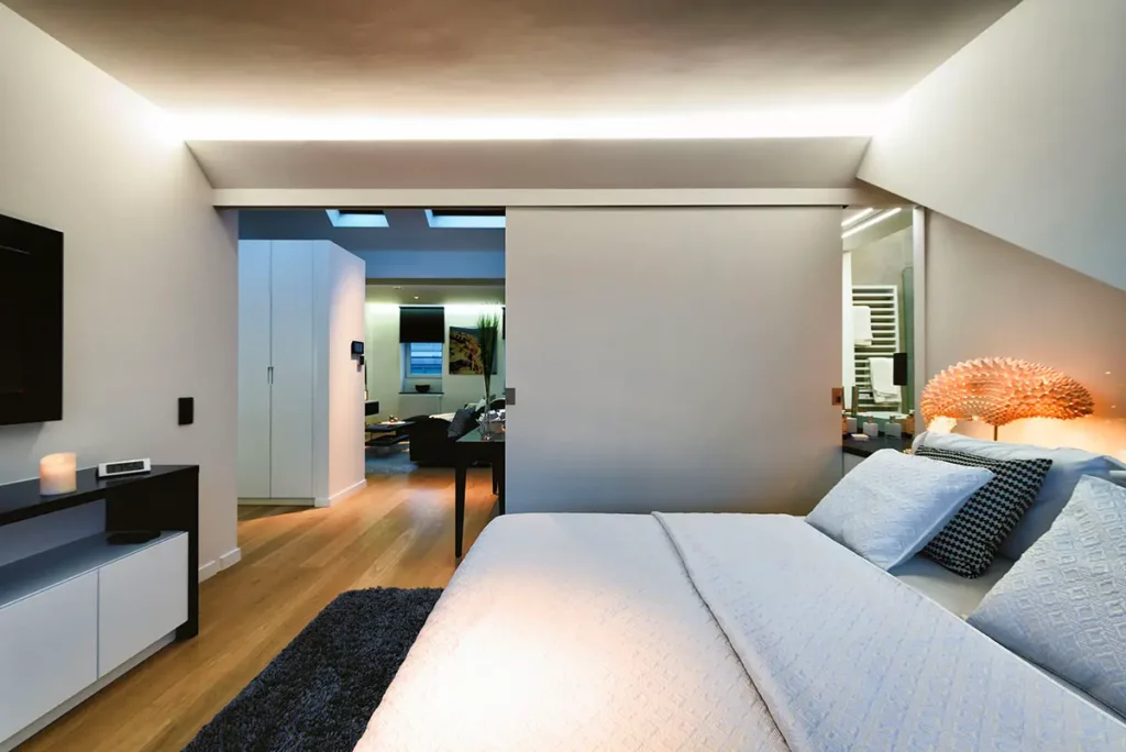 Chambre à coucher élégante aux tons noir et blanc et parquet en bois dans un appart-hôtel Charles Home rue de l'Amazone à Bruxelles