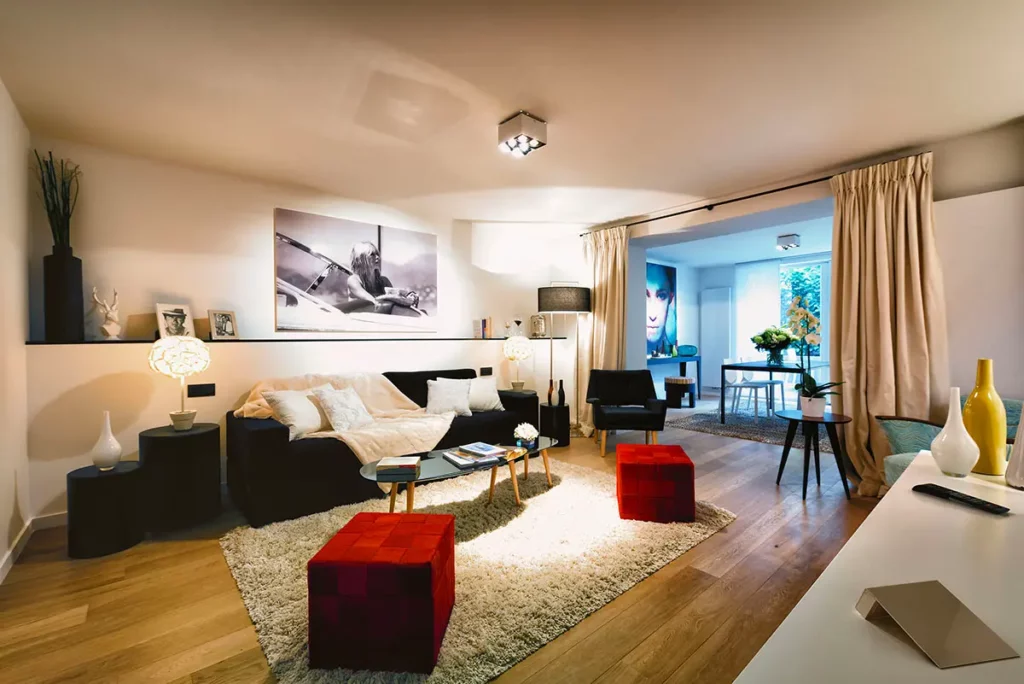 Vue d'ensemble du salon cosy avec mobilier design et parquet dans un appart-hôtel Charles Home à Bruxelles
