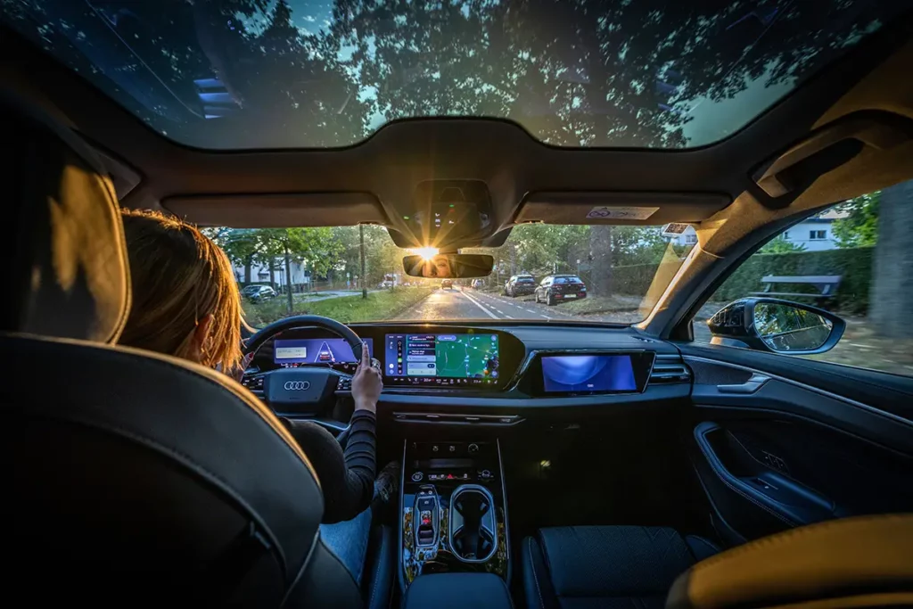 ue intérieure depuis l'arrière de l'Audi A6 allroad e-hybrid, montrant le poste de conduite numérique et le toit panoramique lors de mon essai automobile en Belgique à Woluwe-Saint-Lambert