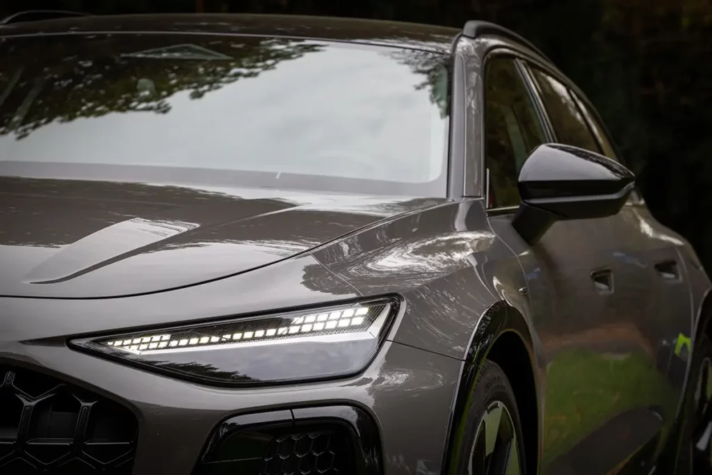 Gros plan sur les optiques avant à LED allumées de l'Audi A6 allroad e-hybrid lors de mon essai automobile en Belgique