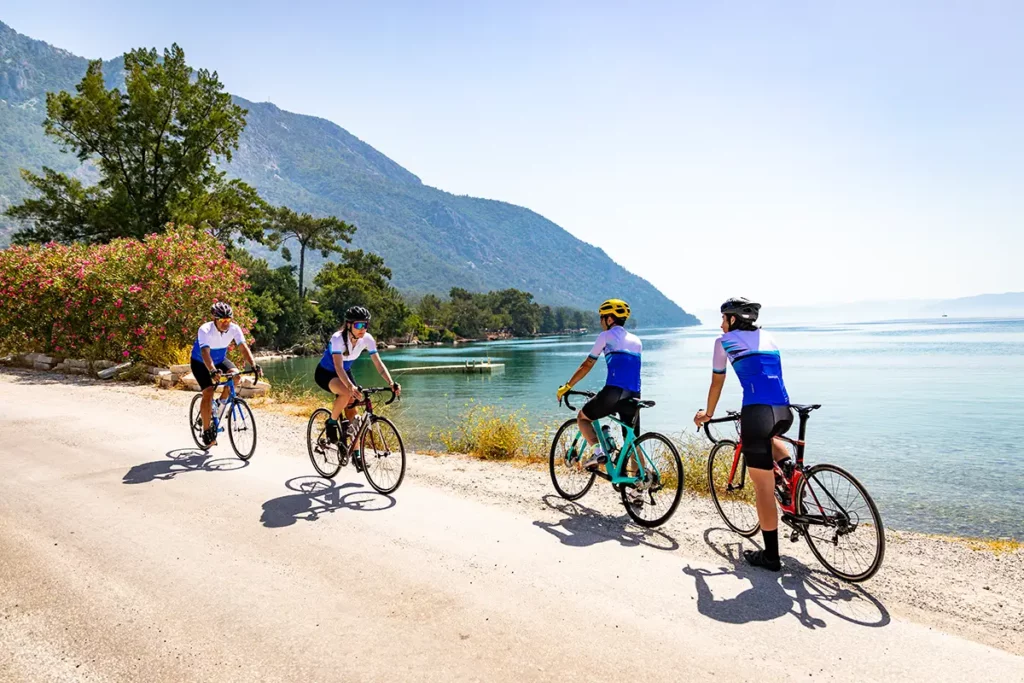 Groupe de cyclistes sur vélo de route longeant la mer turquoise sur une route côtière en Turquie avec Go Türkiye